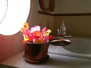 a bucket of flowers sitting next to a sink at Wiborggården Bed and Breakfast in Boda