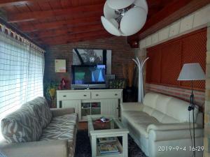 a living room with two couches and a tv at Hospedaje Vega in Santillana del Mar