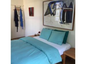 a bedroom with a bed with blue pillows at Bed & Breakfast Leonie in The Hague