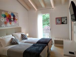 two beds in a room with a window at Le Mandragole B&B in Roncade