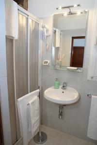 ein weißes Bad mit einem Waschbecken und einer Dusche in der Unterkunft Nerii 3 in Florenz