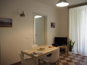 een woonkamer met een tafel en witte stoelen bij Tambù Apartments in Catania