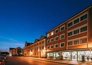 a row of buildings on a street at night at Central City Hotel in Füssen