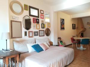 ein Schlafzimmer mit einem großen weißen Bett mit Bildern an der Wand in der Unterkunft Casa Bertiera Bologna Centro in Bologna