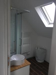 a bathroom with a sink and a glass shower at Maison familiale Groix in Groix