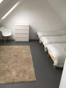 a row of beds in a room with a white dresser at Maison familiale Groix in Groix