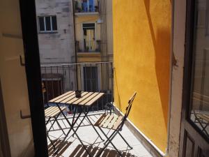 un tavolo e sedie seduti su un balcone di Tambù Apartments a Catania