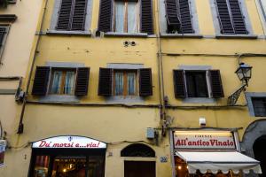 ein gelbes Gebäude mit Fenstern und Fensterläden darauf in der Unterkunft Nerii 3 in Florenz