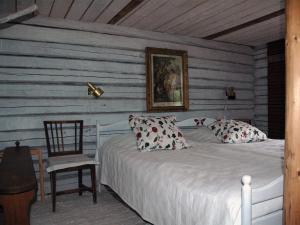 a bedroom with a white bed and a chair at Wiborggården Bed and Breakfast in Boda