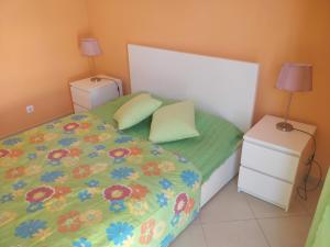 a bedroom with a bed and two night stands with lamps at Casa Nuno in Lagoa