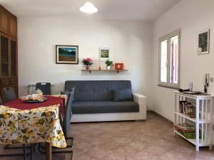 a living room with a couch and a table at Appartamento in Villa Andreina in Orosei