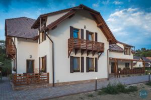 una casa bianca con tetto in legno di Farkas Panzió a Praid