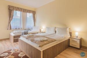 ein großes Bett in einem Schlafzimmer mit großem Fenster in der Unterkunft Farkas Panzió in Praid
