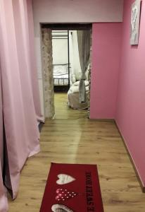 un pasillo con una pared rosa y una alfombra en PAUSE ROMANTIQUE EN PAYS BRAYAUD en Châtel-Guyon