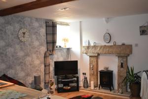 sala de estar con TV y chimenea en LAVENDER COTTAGE en Whitby