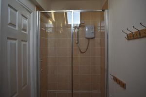 a shower with a glass door in a bathroom at LAVENDER COTTAGE in Whitby +15 photos
