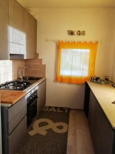 uma cozinha com um lavatório, um fogão e uma janela em La Casetta em Vittorio Veneto