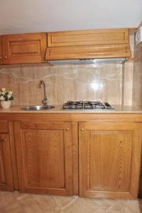 a kitchen with a sink and wooden cabinets at Le Due Sirene in Piano di Sorrento