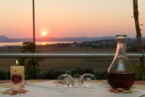 a table with a bottle of wine and a candle at Villa Panorama in Moúdhros