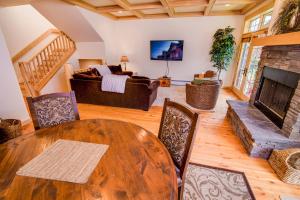 a living room with a wooden table and a fireplace at Spanish Peaks Condo 20 in Big Sky