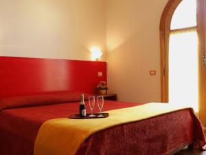1 dormitorio con 1 cama con 2 botellas y 2 vasos en Le Due Sirene, en Piano di Sorrento 8 fotos más