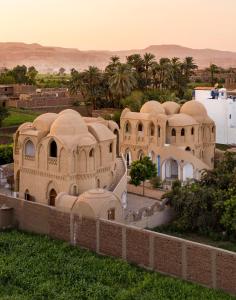 an old building in the desert with palm trees at Leyla Eco Resort Queen Suites in Luxor +20 photos