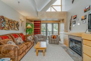 a living room with a couch and a fireplace at Slopeside in Big Sky in Big Sky Mountain Village