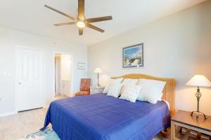 - une chambre avec un lit bleu et un ventilateur de plafond dans l'établissement Palmetto Sunrise, à Litchfield Beach 28 autres photos