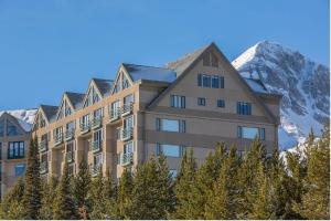 a building with a mountain in the background at Slopeside in Big Sky in Big Sky Mountain Village