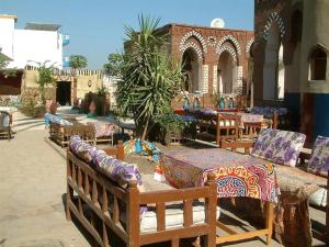 a patio with tables and chairs in a building at Leyla Eco Resort Queen Suites in Luxor