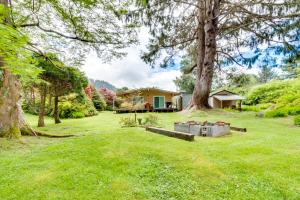 a yard with a house and a tree at Herb's Hideaway in Twin Rocks