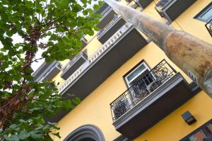 - un bâtiment jaune avec un balcon et une fenêtre dans l'établissement B&B Funikuli Funikula, à Naples