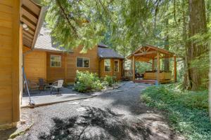 uma cabana na floresta com um alpendre e um pátio em Salmon River Lodge em Welches