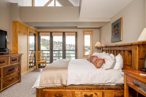 a bedroom with a bed and a tv and a balcony at Shoshone 1986 in Big Sky
