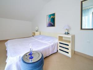 a bedroom with a bed and a table with candles at Apartment Punat in Punat