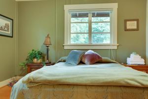 1 cama en un dormitorio con ventana en Molalla River Cottage, en Molalla