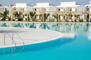 a swimming pool in front of a resort at I GIARDINI DI ZEUS in Metaponto