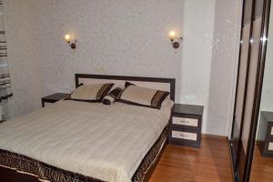 a bedroom with a bed with two night stands and two lamps at Greenhouse in Kropyvnytskyi