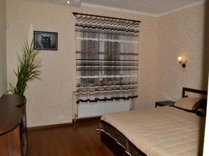 a bedroom with a bed and a window with a radiator at Greenhouse in Kropyvnytskyi