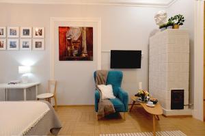 een woonkamer met een blauwe stoel en een tv bij Art Apartments w centrum Krakowa (Śródmieście, Stradom) in Krakau