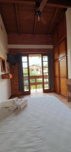 a bedroom with a large bed with two towels on it at Pousada Latitude 27 Bombinhas in Bombinhas +21 photos