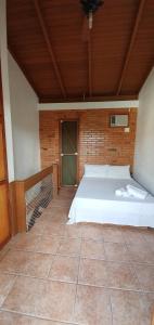a bedroom with a bed and a wooden ceiling at Pousada Latitude 27 Bombinhas in Bombinhas