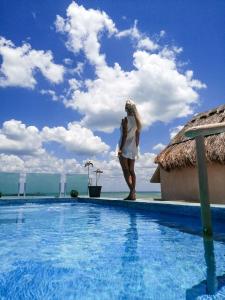 a woman standing on the edge of a swimming pool at Corazon Mexicano Holbox in Holbox Island