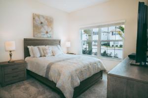 a bedroom with a large bed and a window at Luxury Thownhouse with private pool in Kissimmee