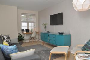 a living room with a blue cabinet and a tv at Glebelands in West Monkton