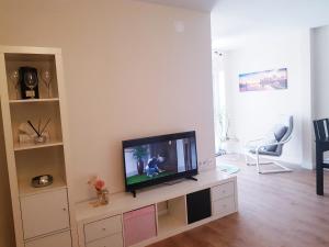salon z telewizorem z płaskim ekranem w centrum rozrywki w obiekcie PRECIOSO ATICO JUNTO A LA FERIA w mieście Jerez de la Frontera