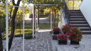a garden with flowers in pots on the stairs at Apartman Dražice-Grobnik in Dražice +7 photos