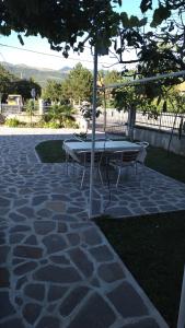 a stone patio with a table and a bench at Apartman Dražice-Grobnik in Dražice