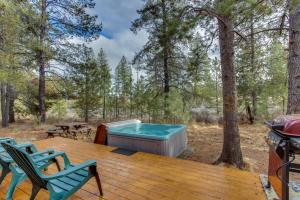 a deck with a hot tub and chairs on a grill at 5 Butternut in Sunriver