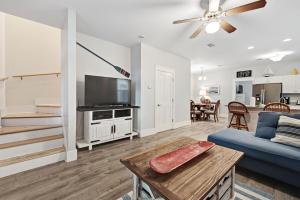 Una sala de estar con un sofá azul y un televisor. en 3 Bed 4 Bath Vacation home in Barefoot Cottages - Port St. Joe, en Highland View